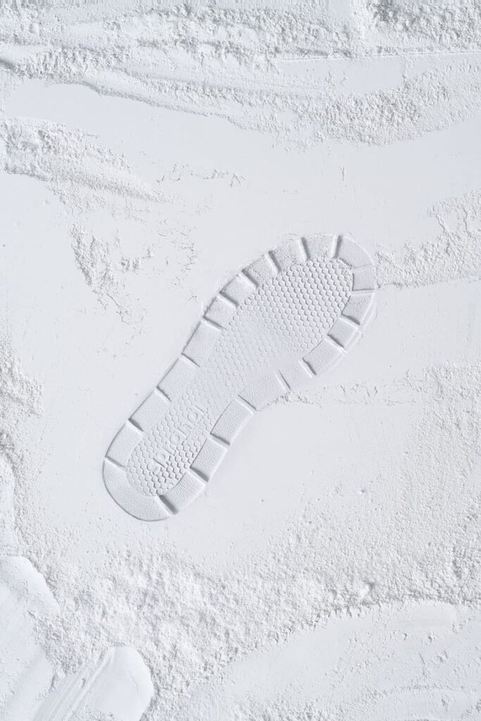 ślad na śniegu po sportowych zimowych butach