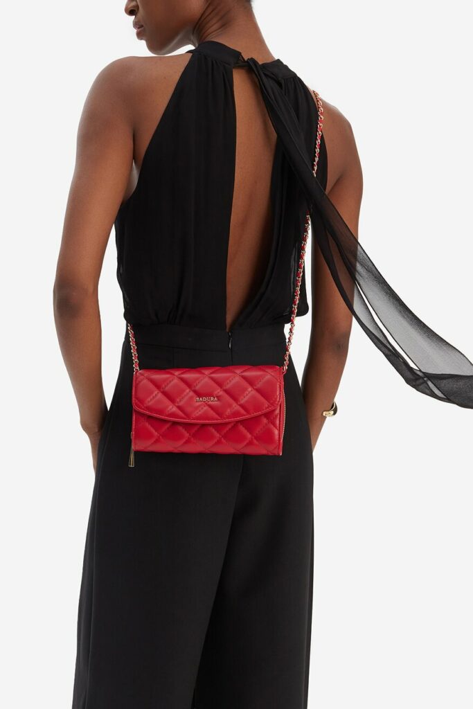 stylizacja z czarnym kombinezonem i czerwoną torebką 